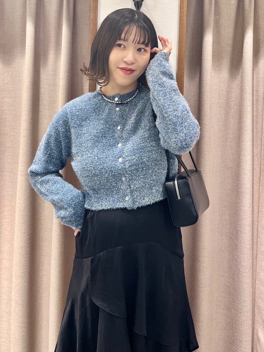 ブルー系のニット/セーター、ブラック系のスカートを着用したレディースの冬コーディネートの3枚目の写真