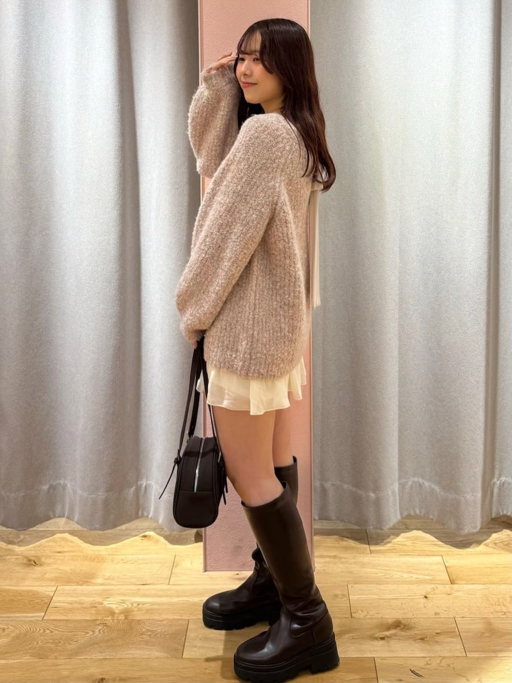 ピンク系のニット/セーター、ホワイト系のスカートを着用したレディースの秋コーディネートの2枚目の写真