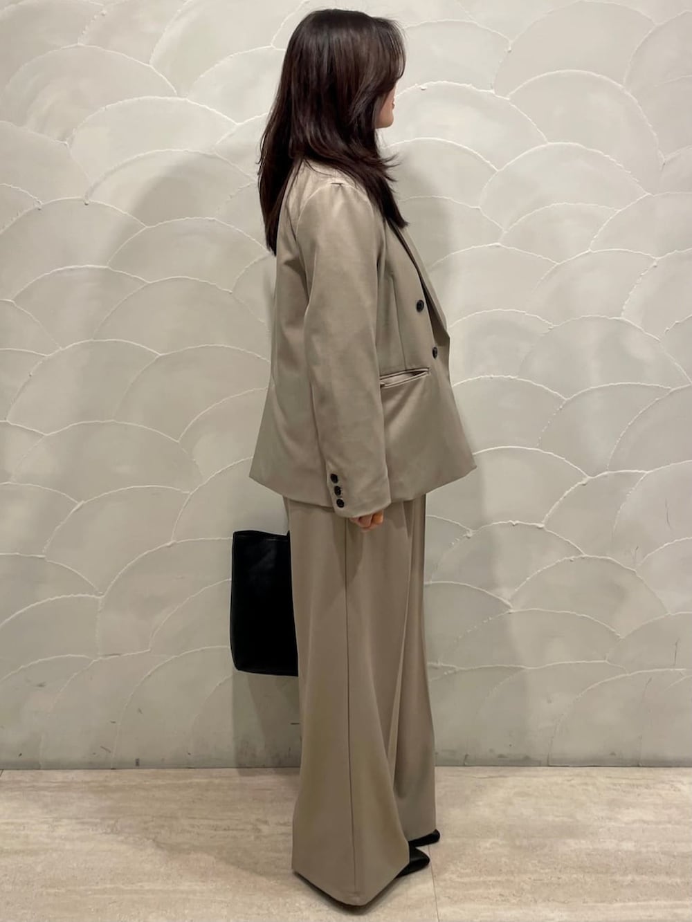 ベージュ系のテーラードジャケット、ベージュ系のスラックス、ホワイト系のシャツ/ブラウスを着用したレディースの春コーディネートの2枚目の写真