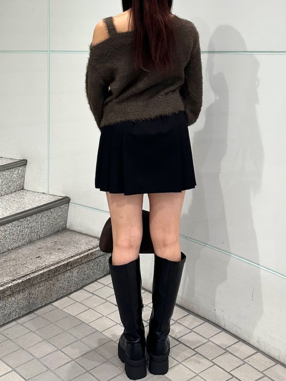 ブラウン系のニット/セーター、ブラック系のスカートを着用したレディースの秋コーディネートの3枚目の写真