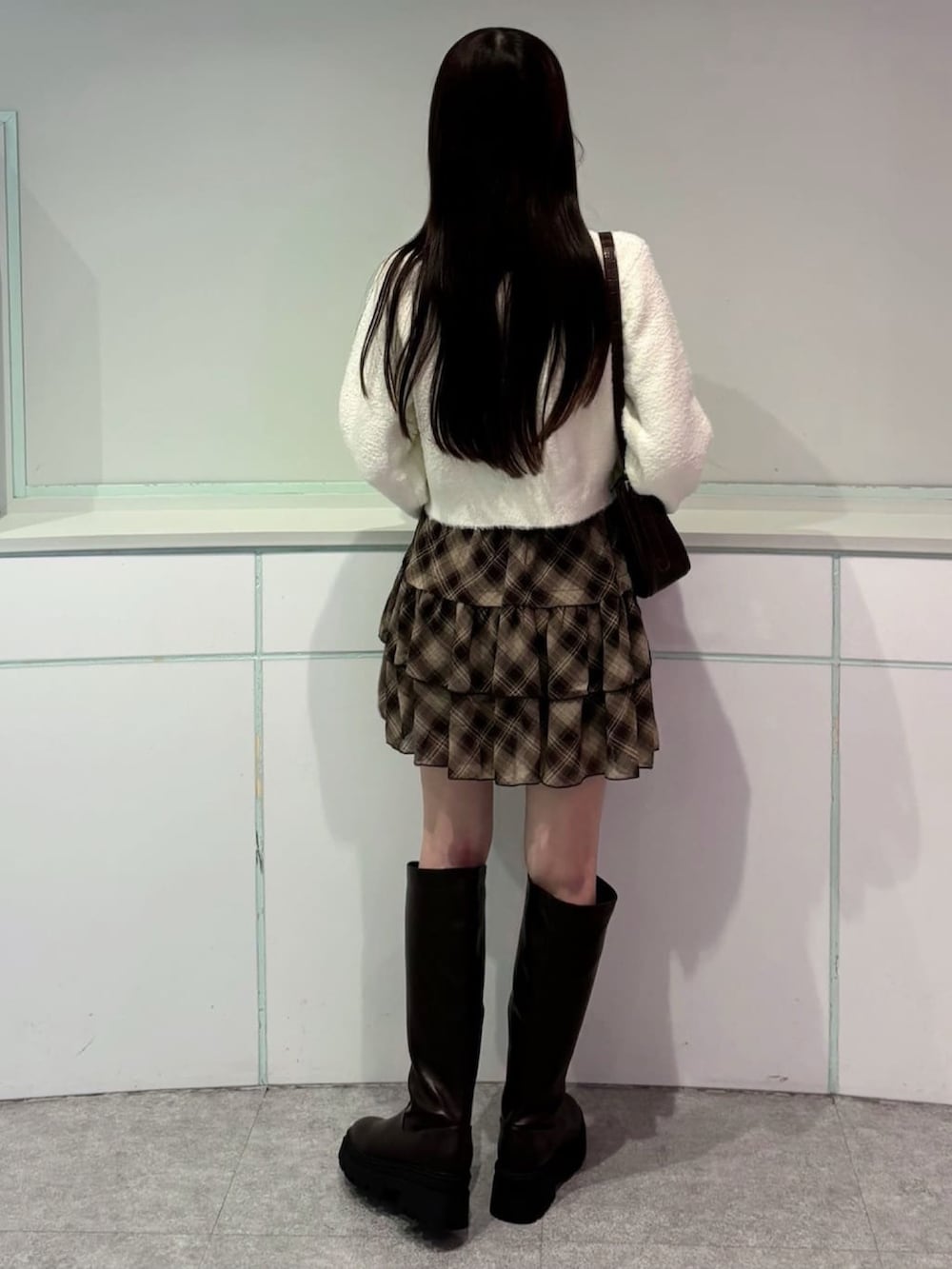 ホワイト系のカーディガン/ボレロ、ブラウン系のスカートを着用したレディースの秋コーディネートの3枚目の写真