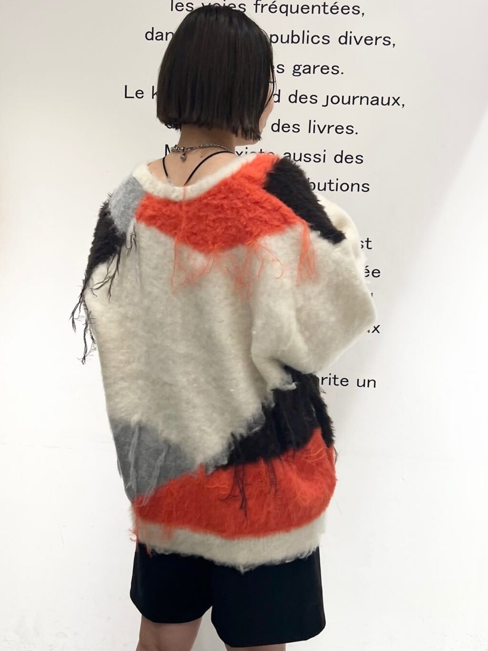 ホワイト系のカーディガン/ボレロ、ブラック系のブーツを着用したレディースの冬コーディネートの2枚目の写真