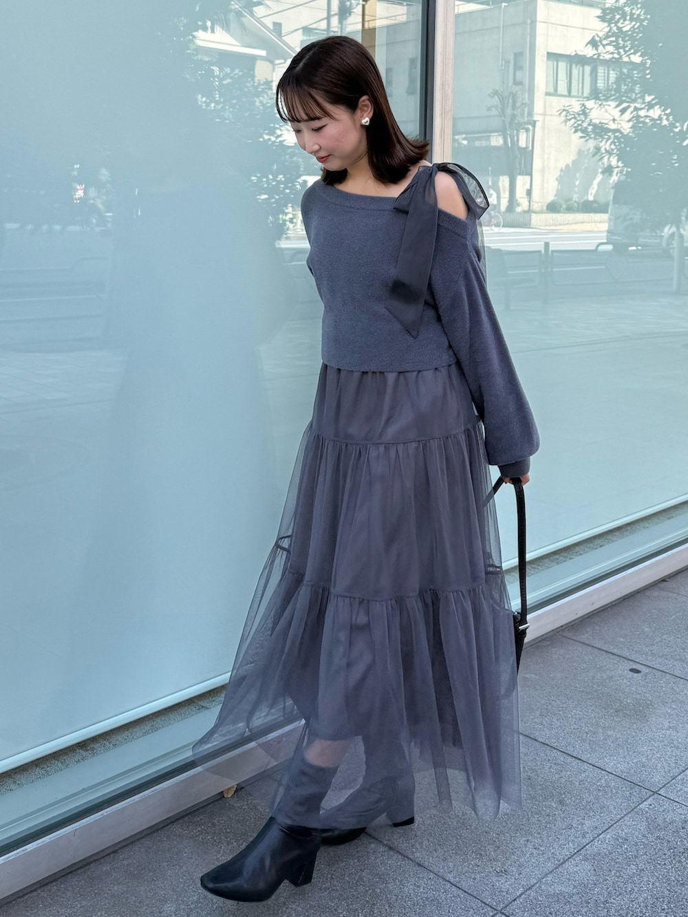 グレー系のワンピース、ブラック系のブーツを着用したレディースの秋コーディネートの2枚目の写真