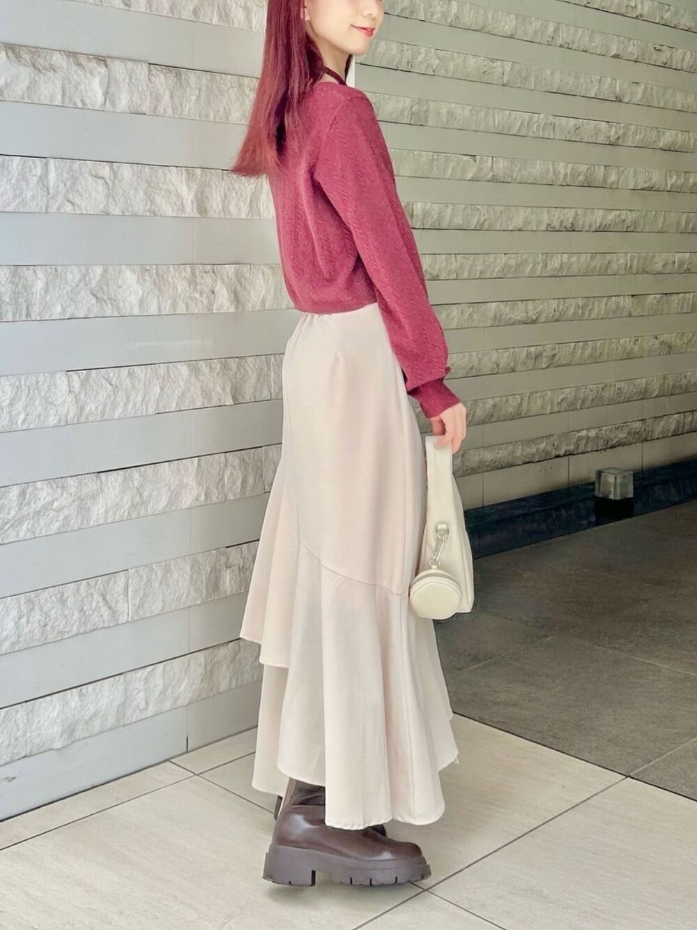 レッド系のカーディガン/ボレロ、ブラック系のスカートを着用したレディースの秋コーディネートの3枚目の写真