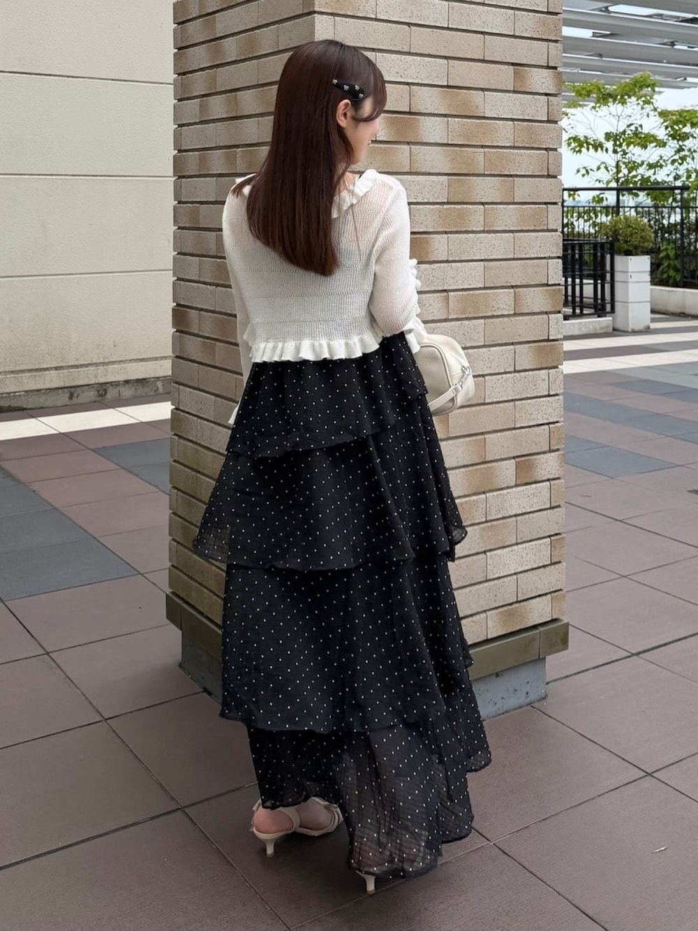 ブラック系のワンピース、ホワイト系のカーディガン/ボレロ、ホワイト系のボストンバッグを着用したレディースの夏コーディネートの3枚目の写真