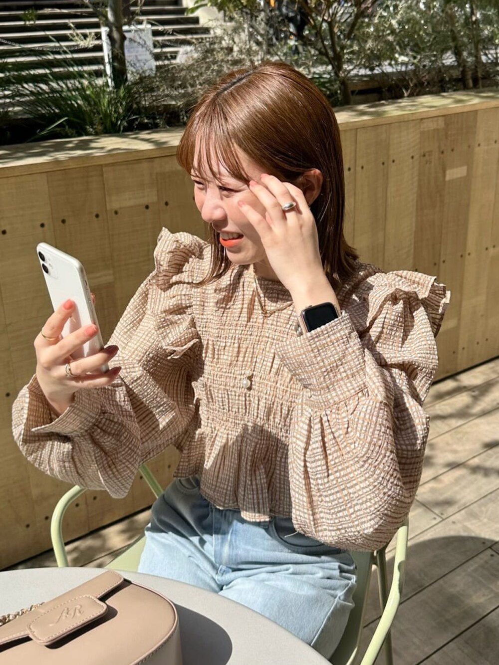 ベージュ系のシャツ/ブラウス、ブルー系のデニムパンツ、ホワイト系のサンダルを着用したレディースの春コーディネートの2枚目の写真