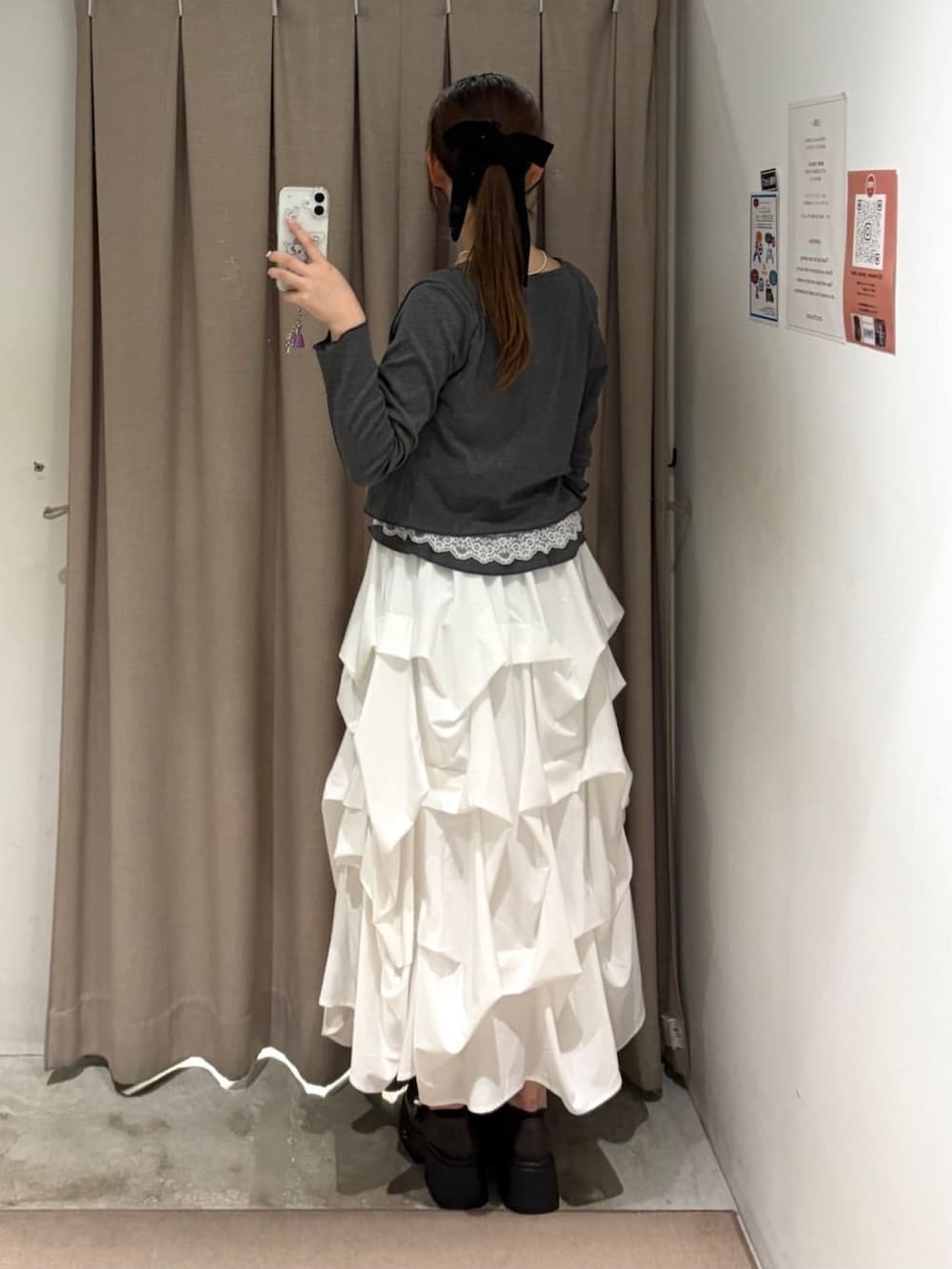 グレー系のTシャツ/カットソー、ブラウン系のショルダーバッグ、ホワイト系のスカートを着用したレディースの秋コーディネートの3枚目の写真