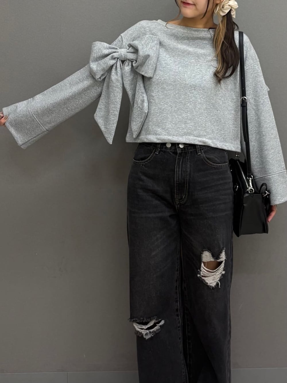 グレー系のTシャツ/カットソー、ブラック系のデニムパンツ、ブラック系のショルダーバッグを着用したレディースの秋コーディネートの4枚目の写真