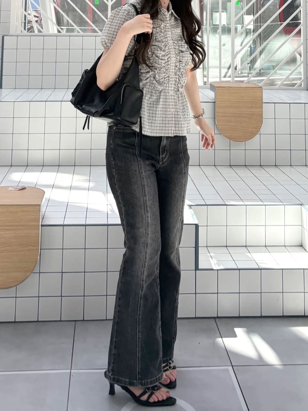 グレー系のデニムパンツ、ブラック系のサンダル、ブラック系のショルダーバッグを着用したレディースの夏コーディネートの2枚目の写真