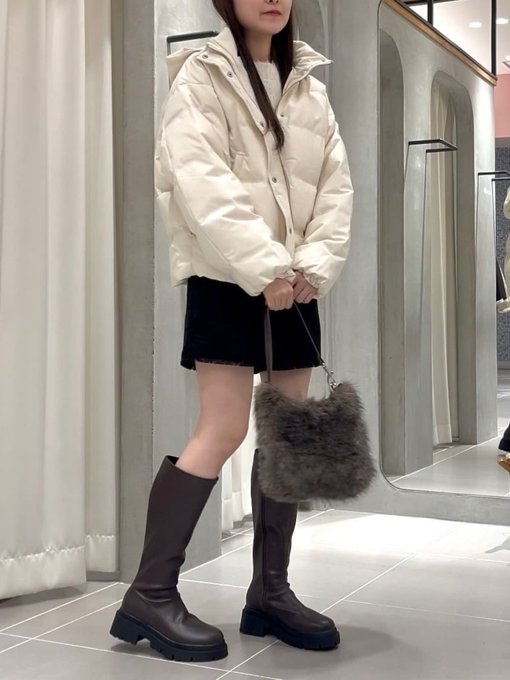 ホワイト系のダウンジャケット/コート、ブラック系のその他パンツ、ブラウン系のショルダーバッグを着用したレディースの冬コーディネートの3枚目の写真