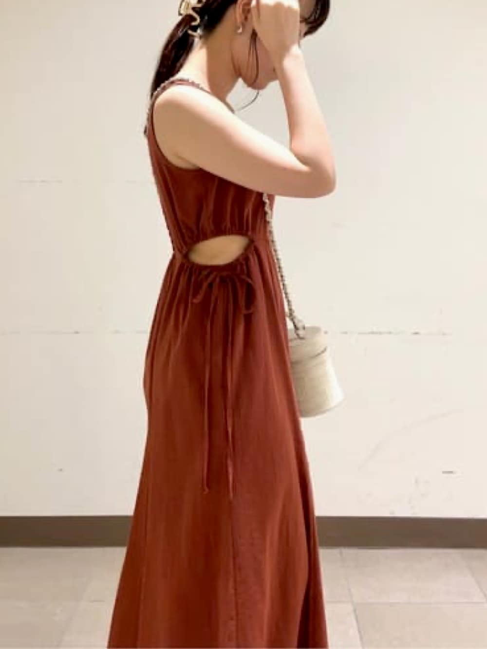 レッド系のワンピース、ホワイト系のショルダーバッグ、ホワイト系のサンダルを着用したレディースの夏コーディネートの3枚目の写真