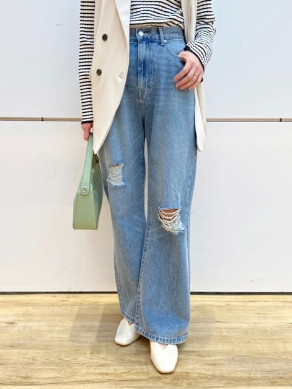 ホワイト系のベスト、ホワイト系のニット/セーター、ブルー系のデニムパンツを着用したレディースの冬コーディネートの3枚目の写真