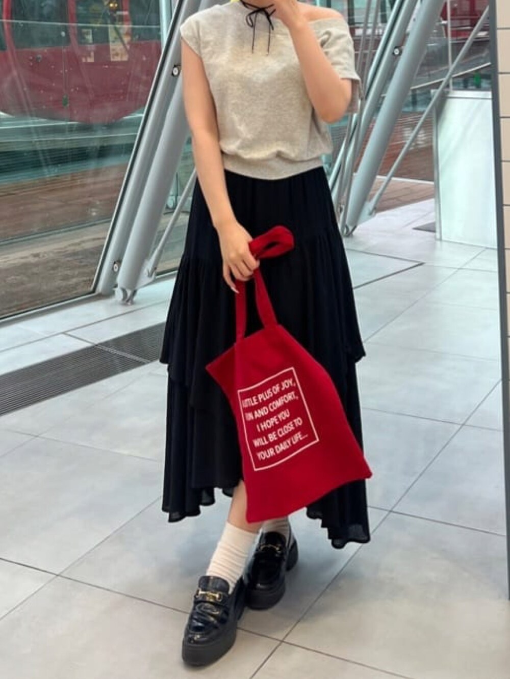 グレー系のスウェット、ブラック系のスカートを着用したレディースの夏コーディネートの2枚目の写真