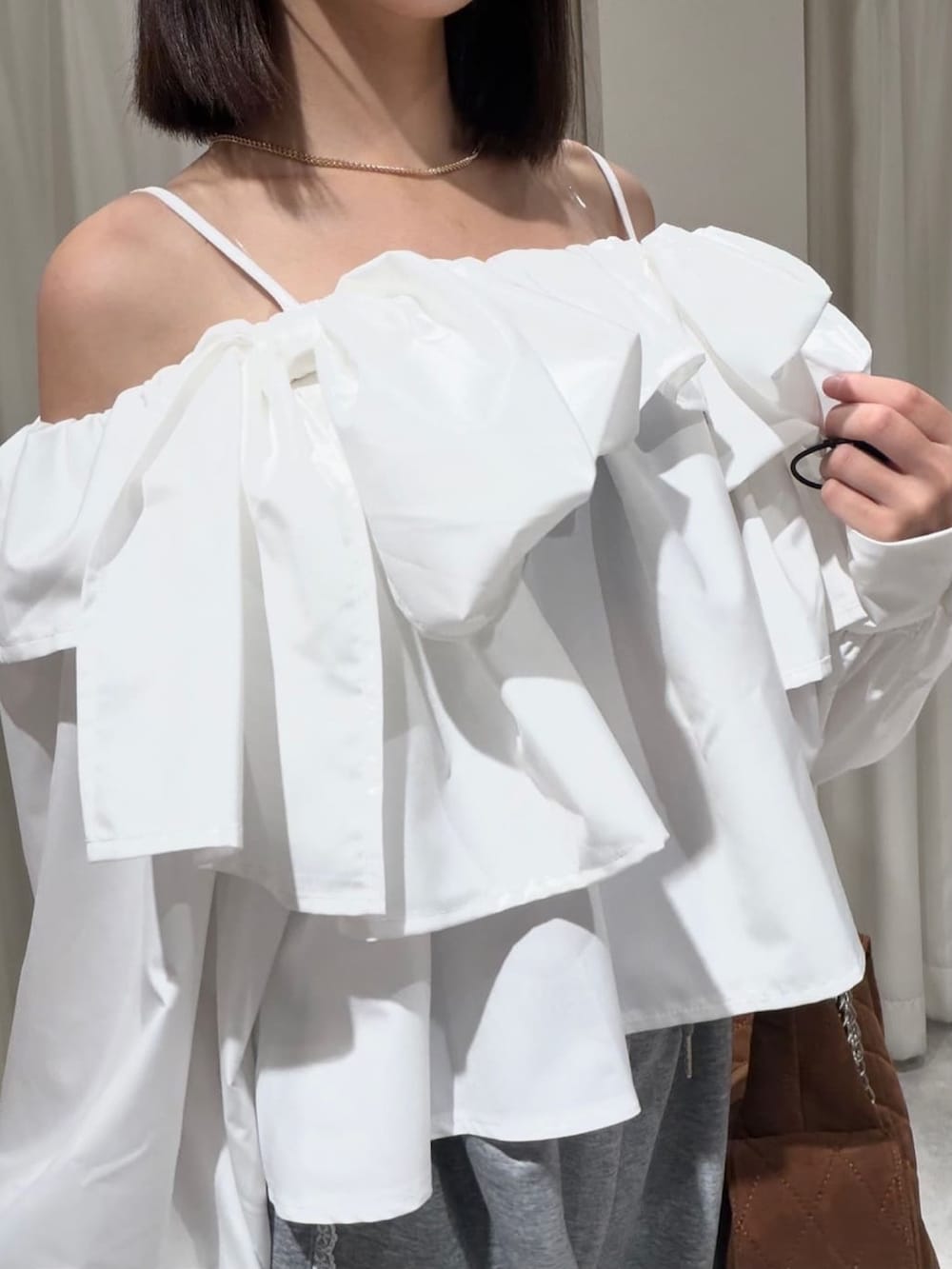 ホワイト系のシャツ/ブラウス、グレー系のスウェットパンツ、ブラウン系のショルダーバッグを着用したレディースの夏コーディネートの3枚目の写真
