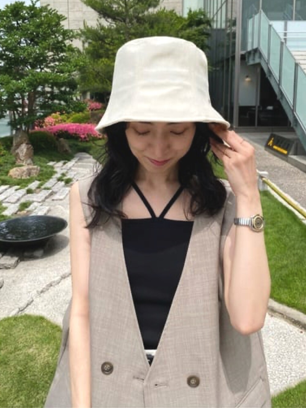 ブラウン系のその他アウター、ブラック系のキャミソール、ホワイト系のハットを着用したレディースの春コーディネートの2枚目の写真