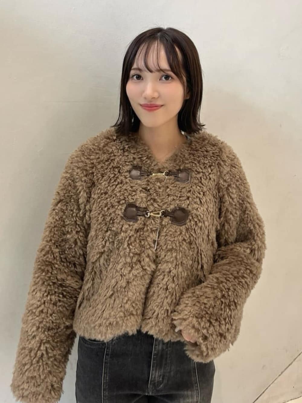 ブラウン系のダッフルコート、グレー系のデニムパンツを着用したレディースの秋コーディネートの3枚目の写真