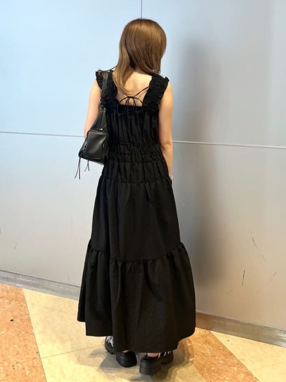 ブラック系のワンピース、グレー系のサンダル、ブラック系のショルダーバッグを着用したレディースの夏コーディネートの2枚目の写真