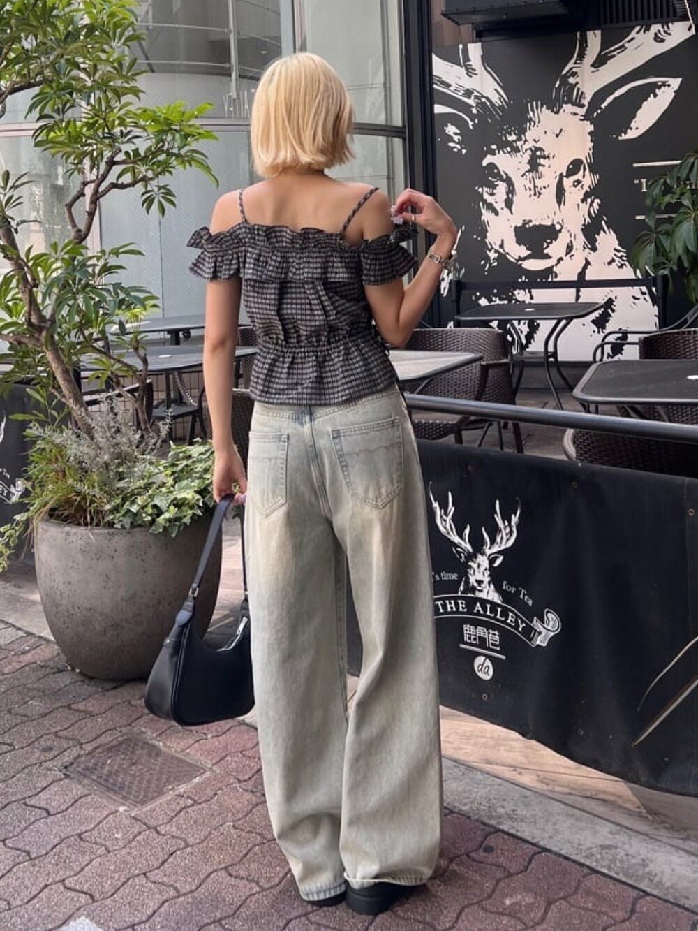 ブラック系のシャツ/ブラウス、ブルー系のデニムパンツを着用したレディースの夏コーディネートの3枚目の写真