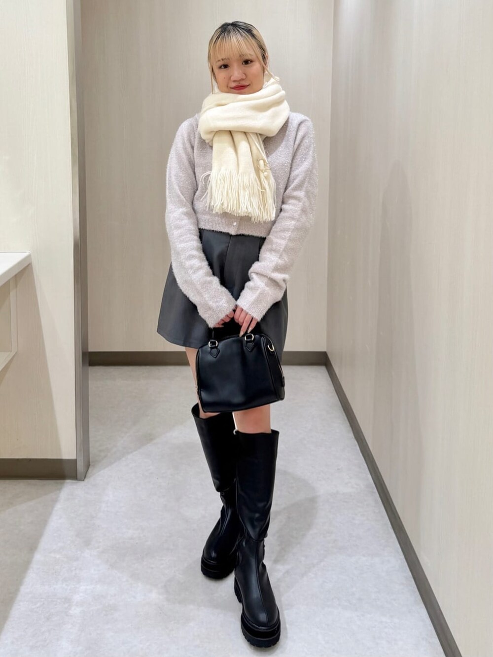ピンク系のニット/セーター、グレー系のその他パンツ、ブラック系のブーツを着用したレディースの冬コーディネートの2枚目の写真