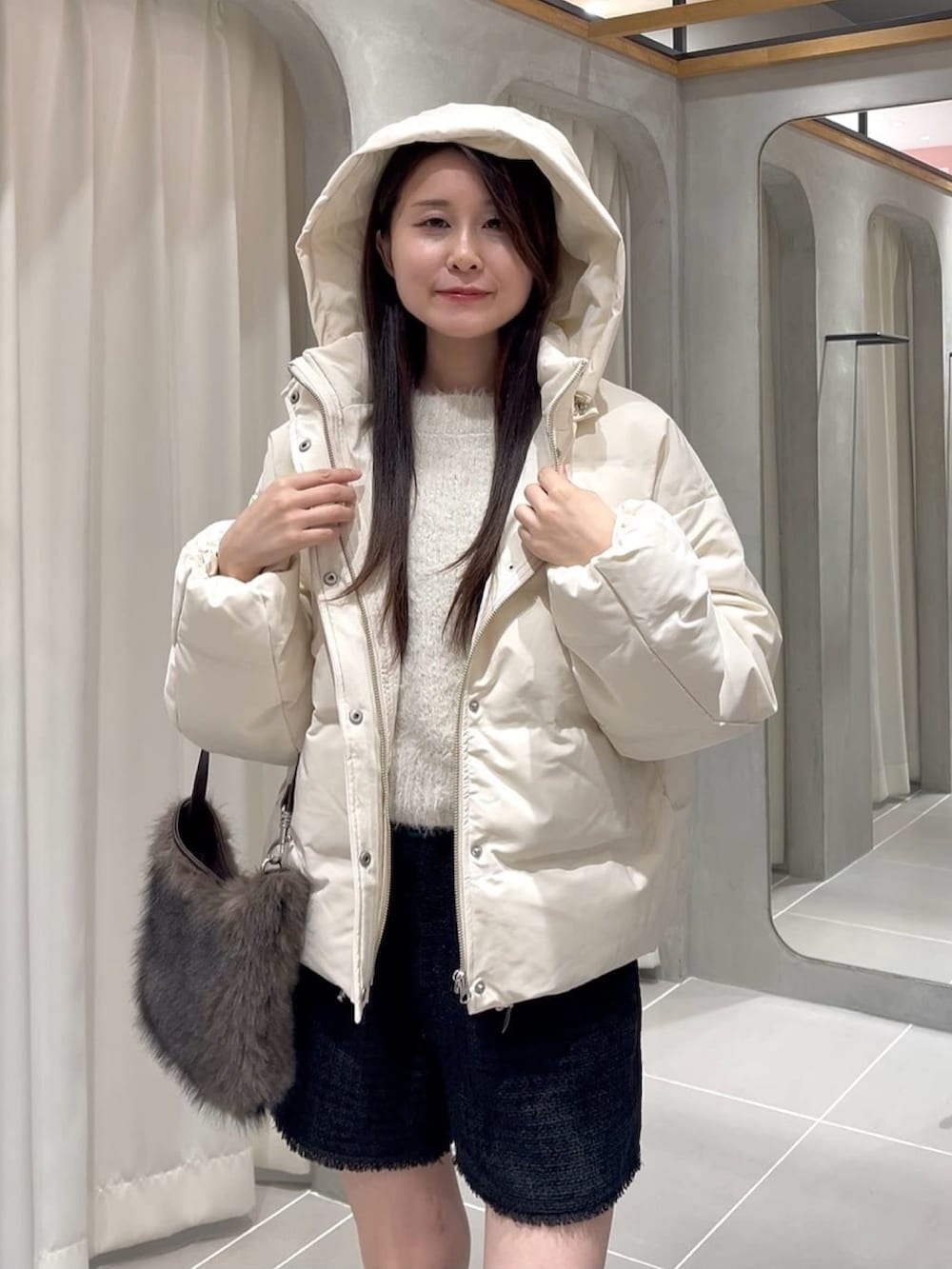 ホワイト系のダウンジャケット/コート、ブラック系のその他パンツ、ブラウン系のショルダーバッグを着用したレディースの冬コーディネートの2枚目の写真