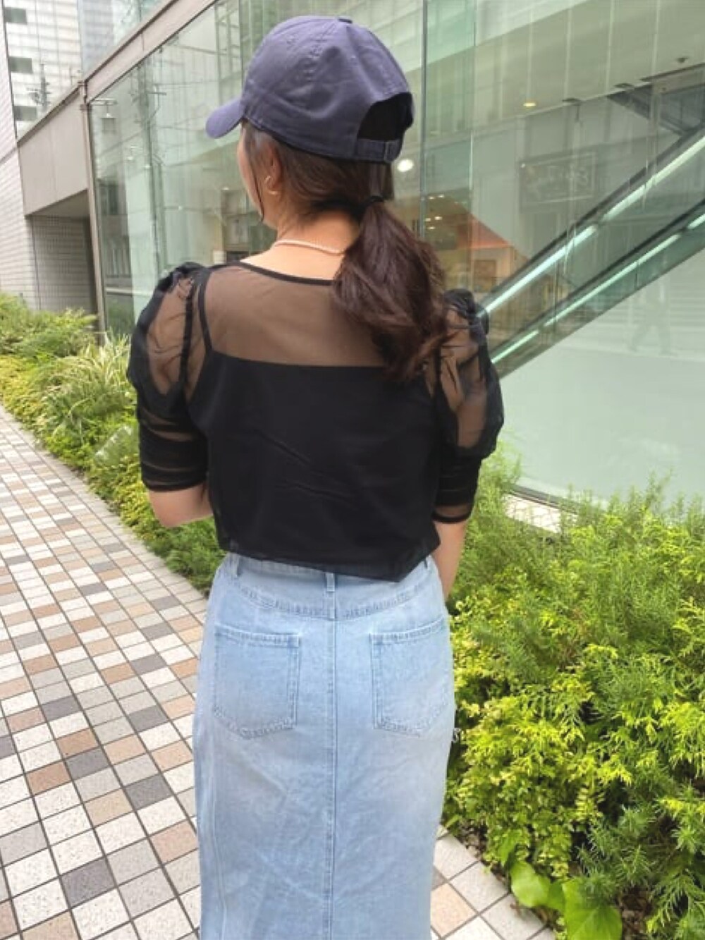 ブラック系のTシャツ/カットソー、ブルー系のデニムスカートを着用したレディースの夏コーディネートの3枚目の写真