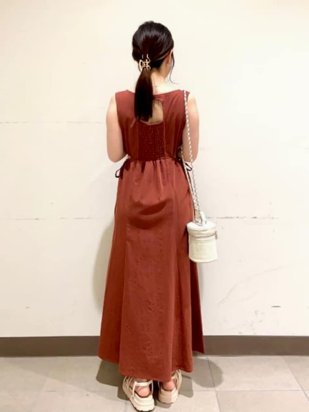 レッド系のワンピース、ホワイト系のショルダーバッグ、ホワイト系のサンダルを着用したレディースの夏コーディネートの2枚目の写真