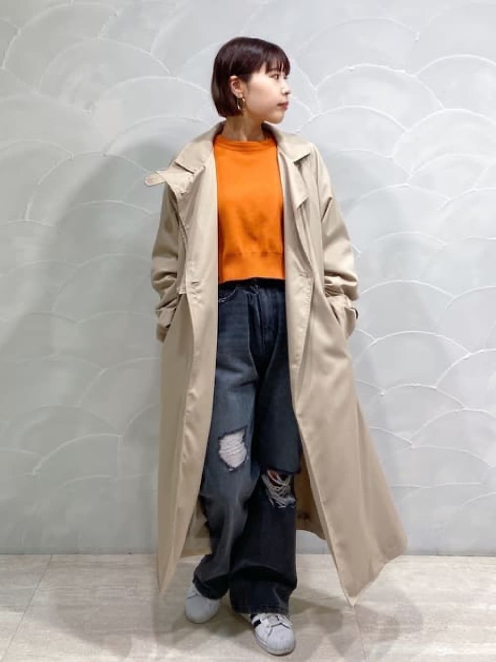 ベージュ系のトレンチコート、ブラック系のボストンバッグ、ブラック系のデニムパンツを着用したレディースの春コーディネートの3枚目の写真