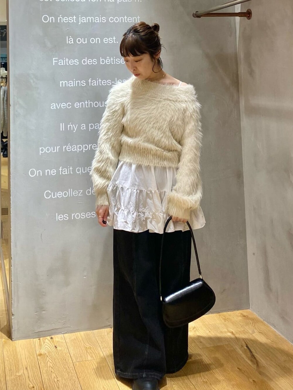 ホワイト系のニット/セーター、ホワイト系のワンピース、ブラウン系のショルダーバッグを着用したレディースの冬コーディネートの2枚目の写真