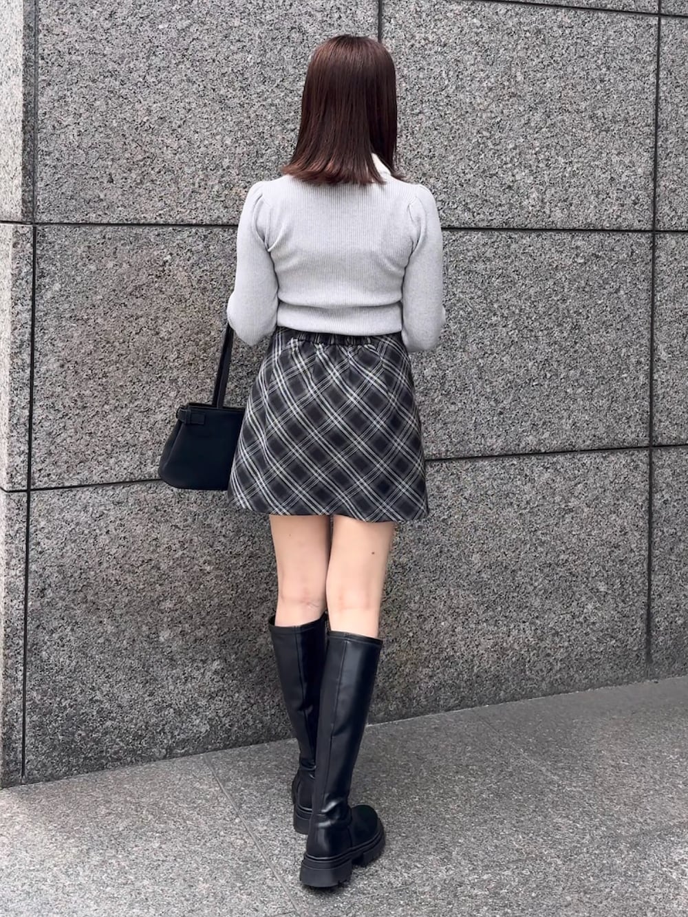 グレー系のニット/セーター、グレー系のスカートを着用したレディースの秋コーディネートの4枚目の写真