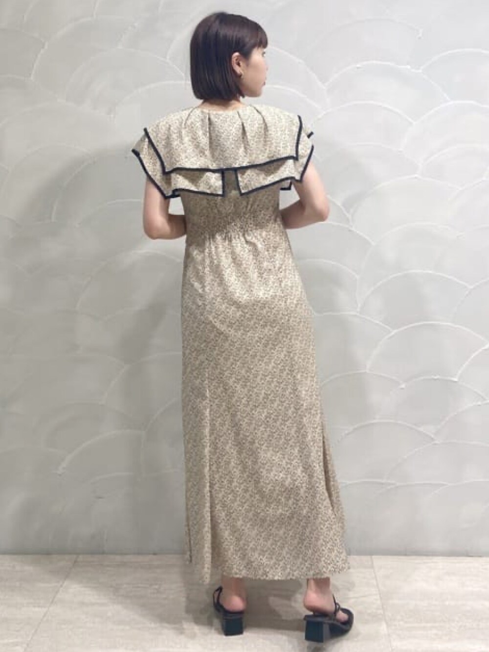 ベージュ系のワンピース、ブラック系のサンダルを着用したレディースの夏コーディネートの2枚目の写真