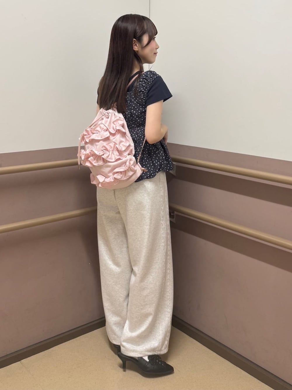 ベージュ系のスウェットパンツ、ブラック系のパンプス、ブラック系のTシャツ/カットソーを着用したレディースの夏コーディネートの3枚目の写真