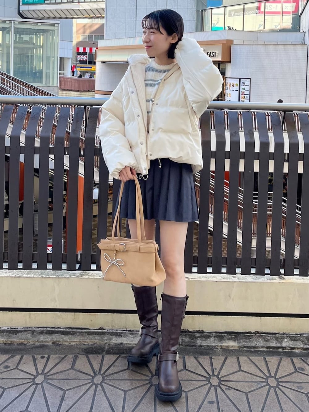 ホワイト系のニット/セーター、グレー系のスカートを着用したレディースの冬コーディネートの2枚目の写真