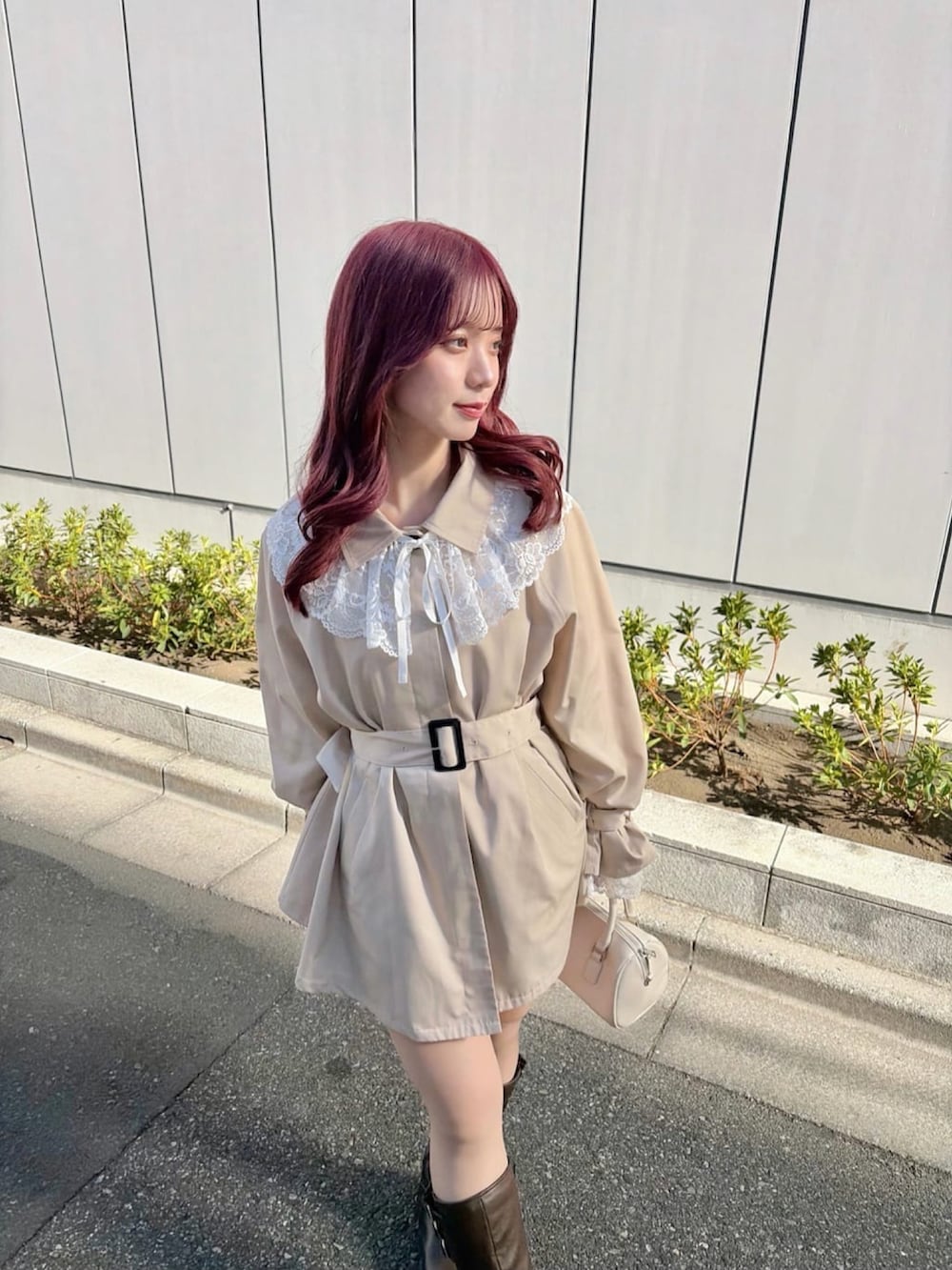 ベージュ系のトレンチコート、ブラウン系のブーツを着用したレディースの冬コーディネートの2枚目の写真