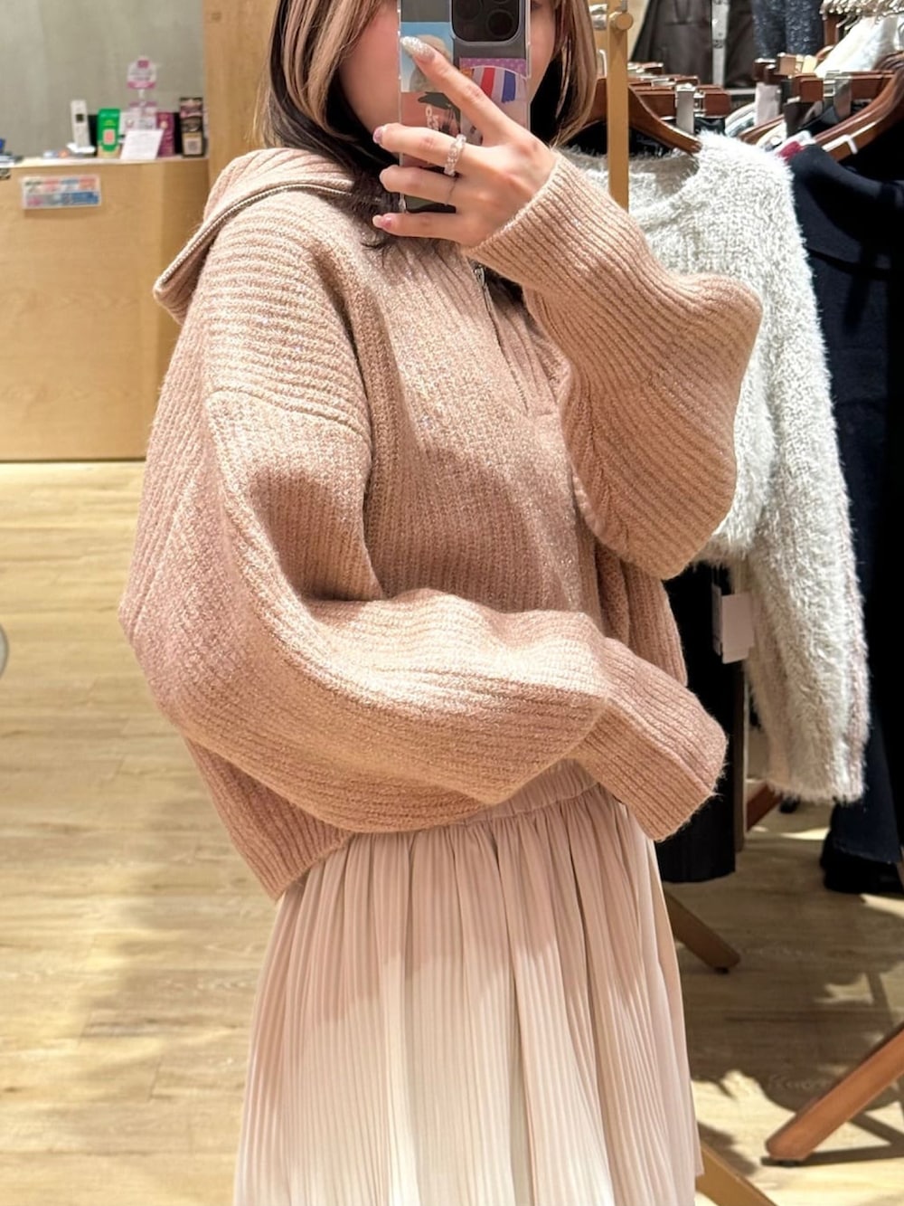 ホワイト系のスカート、ブラウン系のブーツ、ピンク系のニット/セーターを着用したレディースの冬コーディネートの3枚目の写真