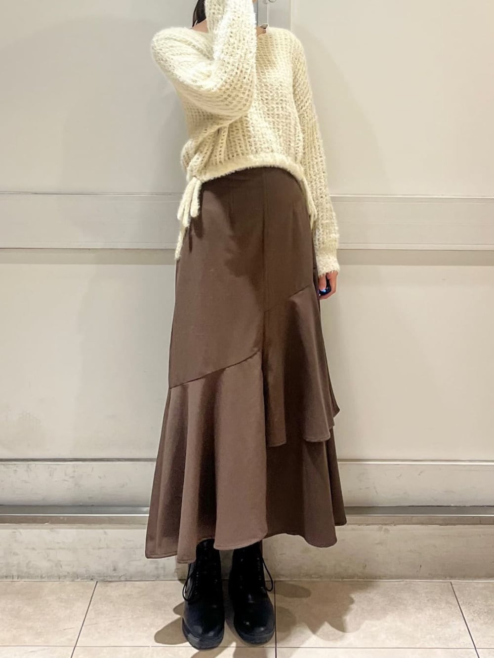 ホワイト系のその他アウター、ホワイト系のニット/セーター、ブラウン系のスカートを着用したレディースの冬コーディネートの3枚目の写真