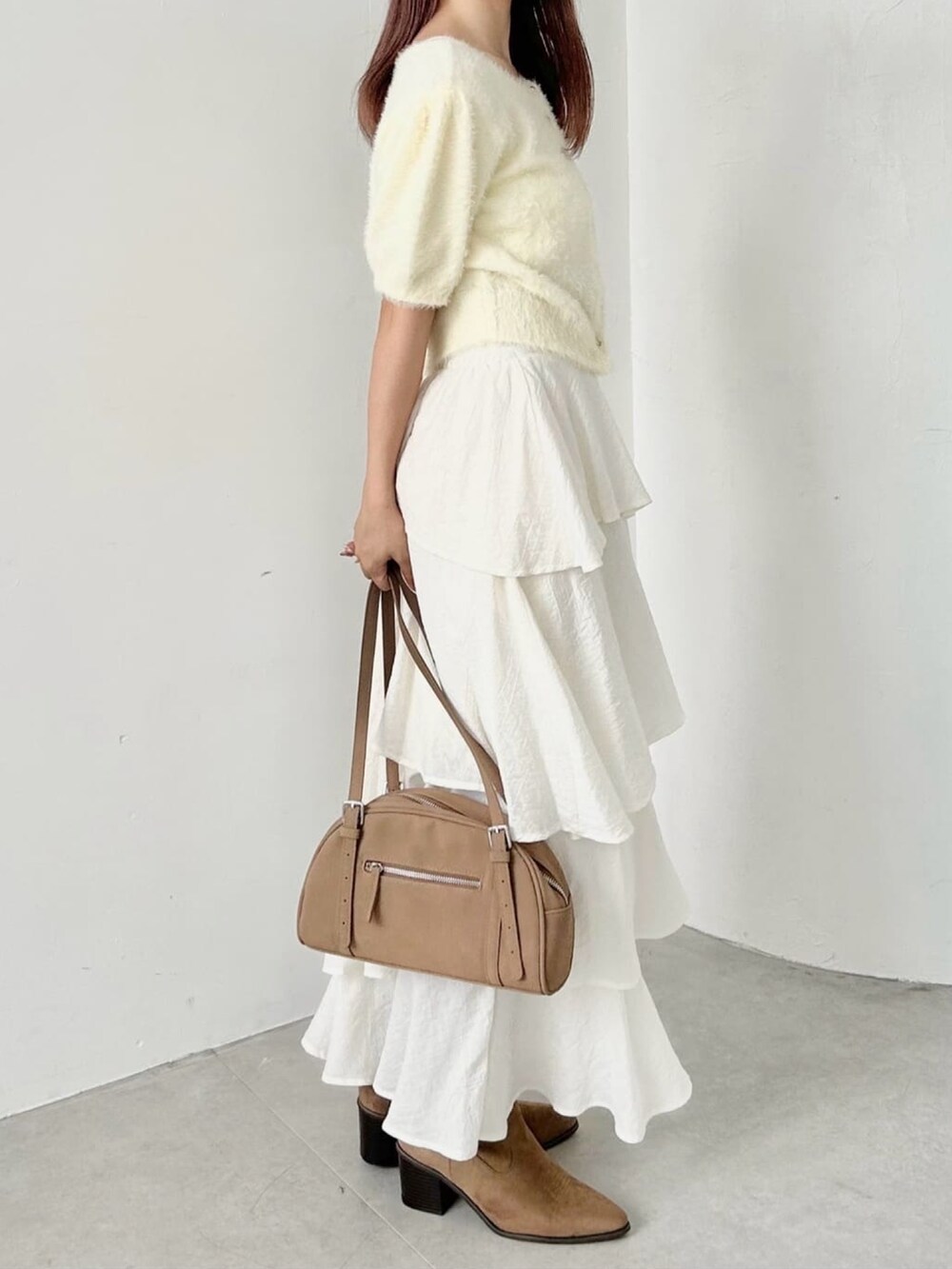 グリーン系のカーディガン/ボレロ、ホワイト系のスカートを着用したレディースの秋コーディネートの2枚目の写真