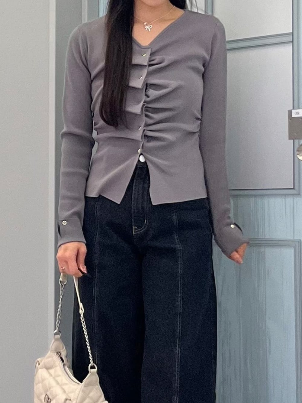 ホワイト系のニット/セーター、ブラック系のデニムパンツを着用したレディースの冬コーディネートの2枚目の写真