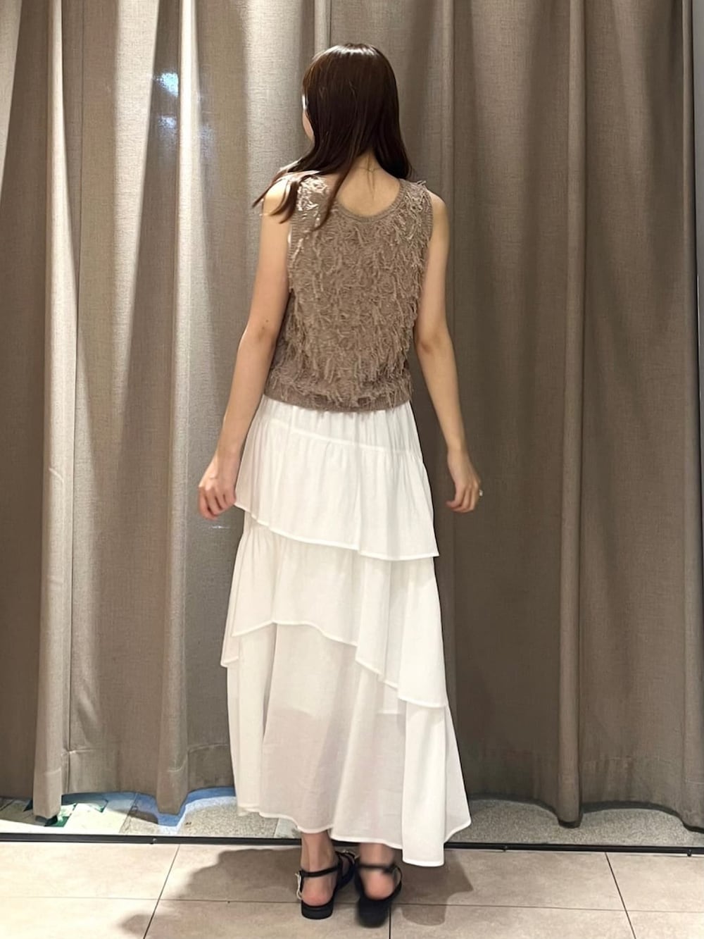 ブラウン系のベストを着用したレディースの夏コーディネートの3枚目の写真