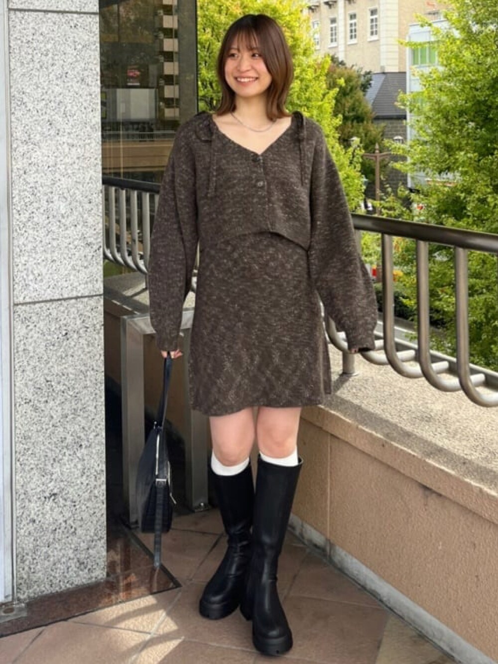 ブラウン系のワンピースを着用したレディースの秋コーディネートの2枚目の写真