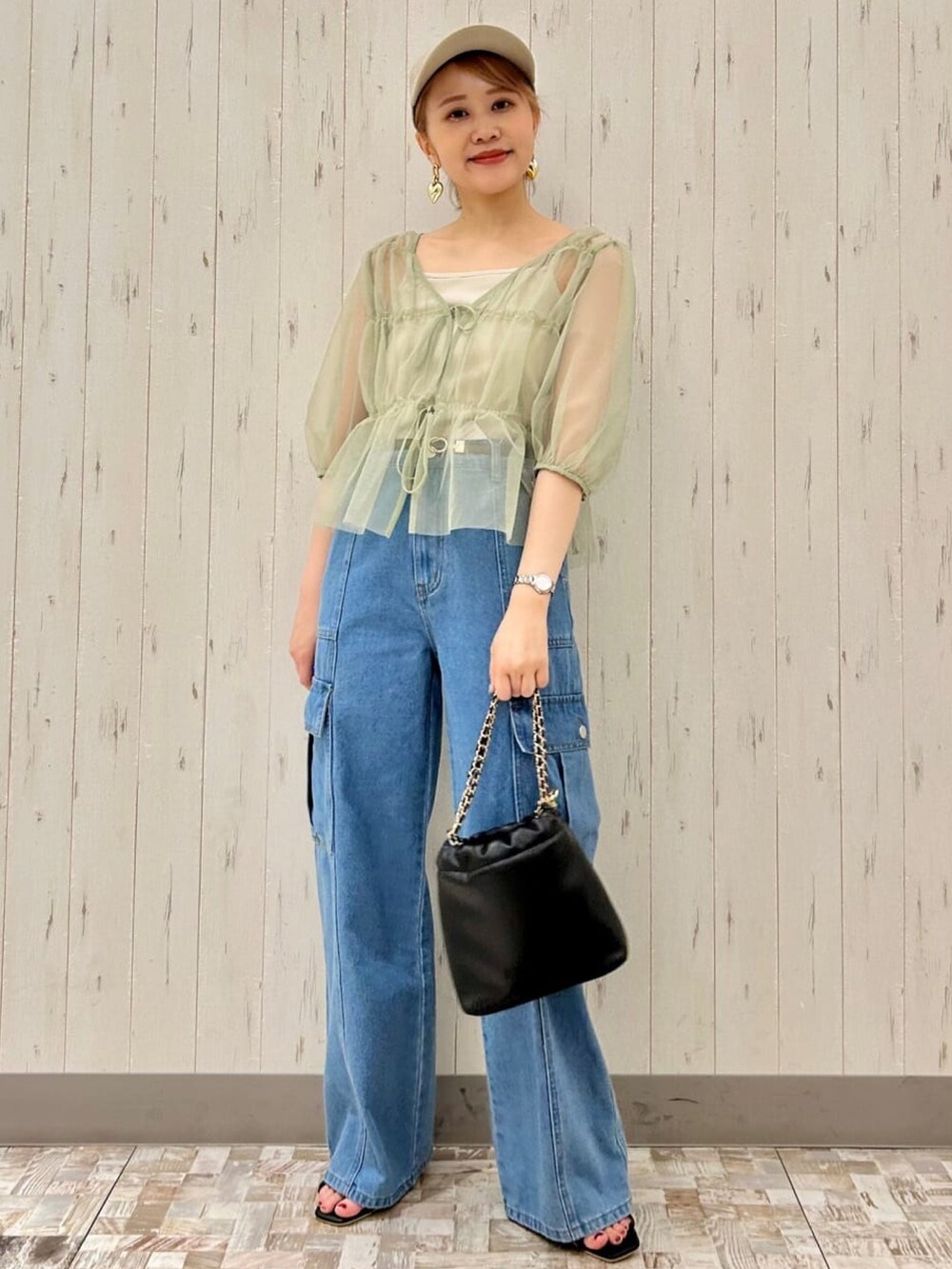 グリーン系のシャツ/ブラウス、ブルー系のデニムパンツ、ブラック系のハンドバッグを着用したレディースの夏コーディネートの3枚目の写真
