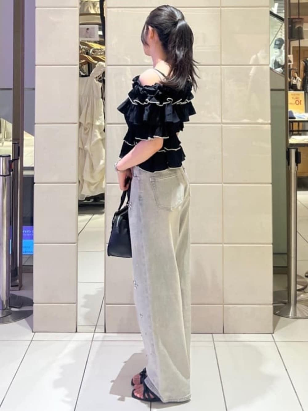 ブラック系のシャツ/ブラウス、ブルー系のデニムパンツ、ブラック系のショルダーバッグを着用したレディースの夏コーディネートの2枚目の写真