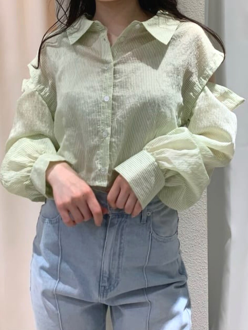 グリーン系のシャツ/ブラウス、ブルー系のデニムパンツ、グリーン系のハンドバッグを着用したレディースの春コーディネートの2枚目の写真