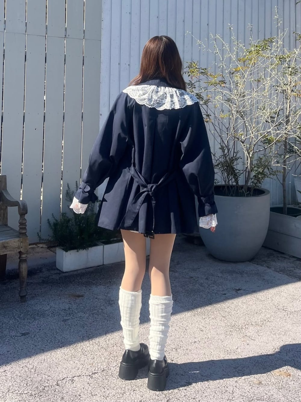 ブルー系のトレンチコート、イエロー系のカーディガン/ボレロを着用したレディースの冬コーディネートの3枚目の写真