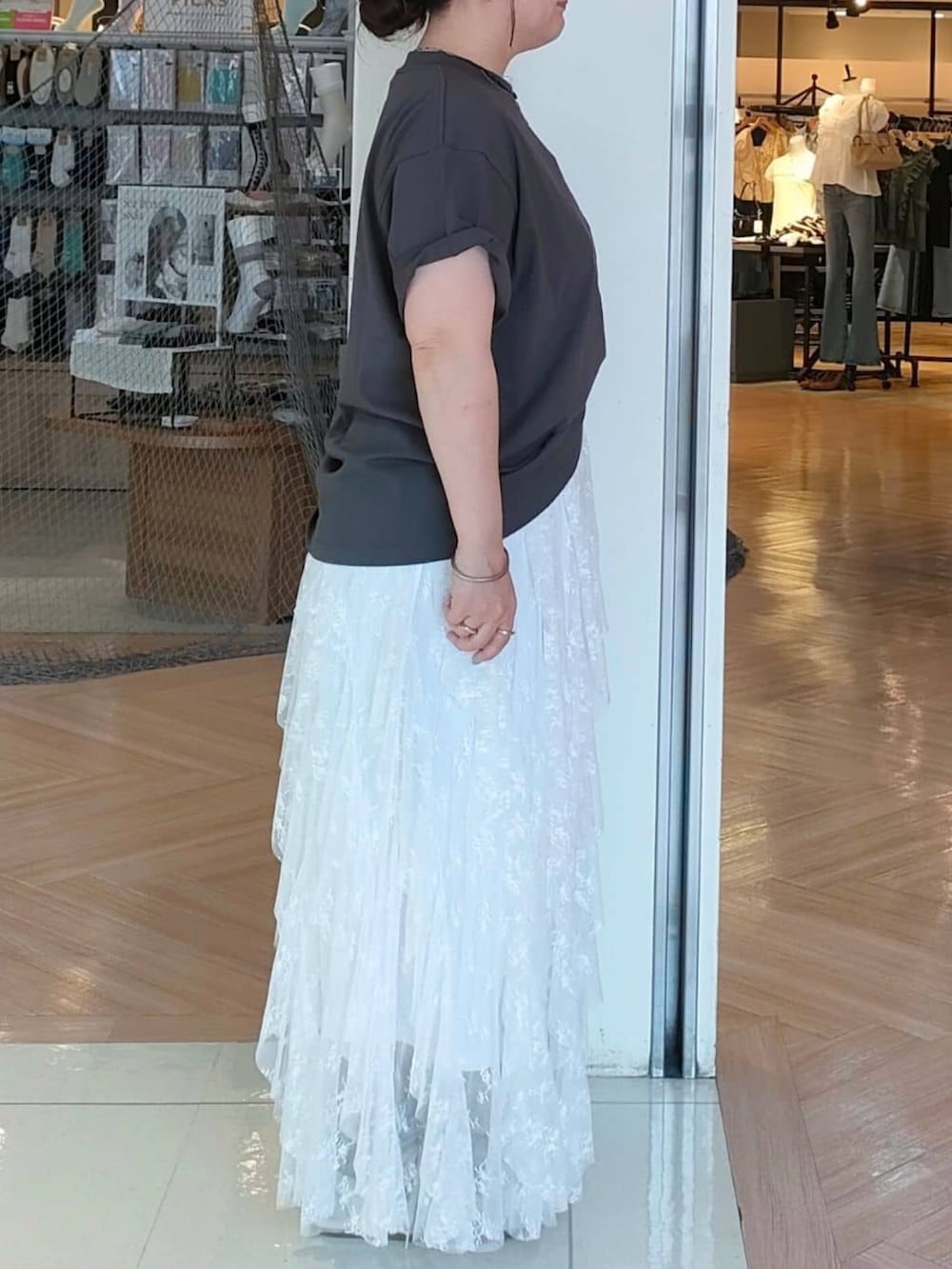 グレー系のTシャツ/カットソー、ブルー系のエコバッグ/サブバッグ、ホワイト系のスカートを着用したレディースの夏コーディネートの2枚目の写真