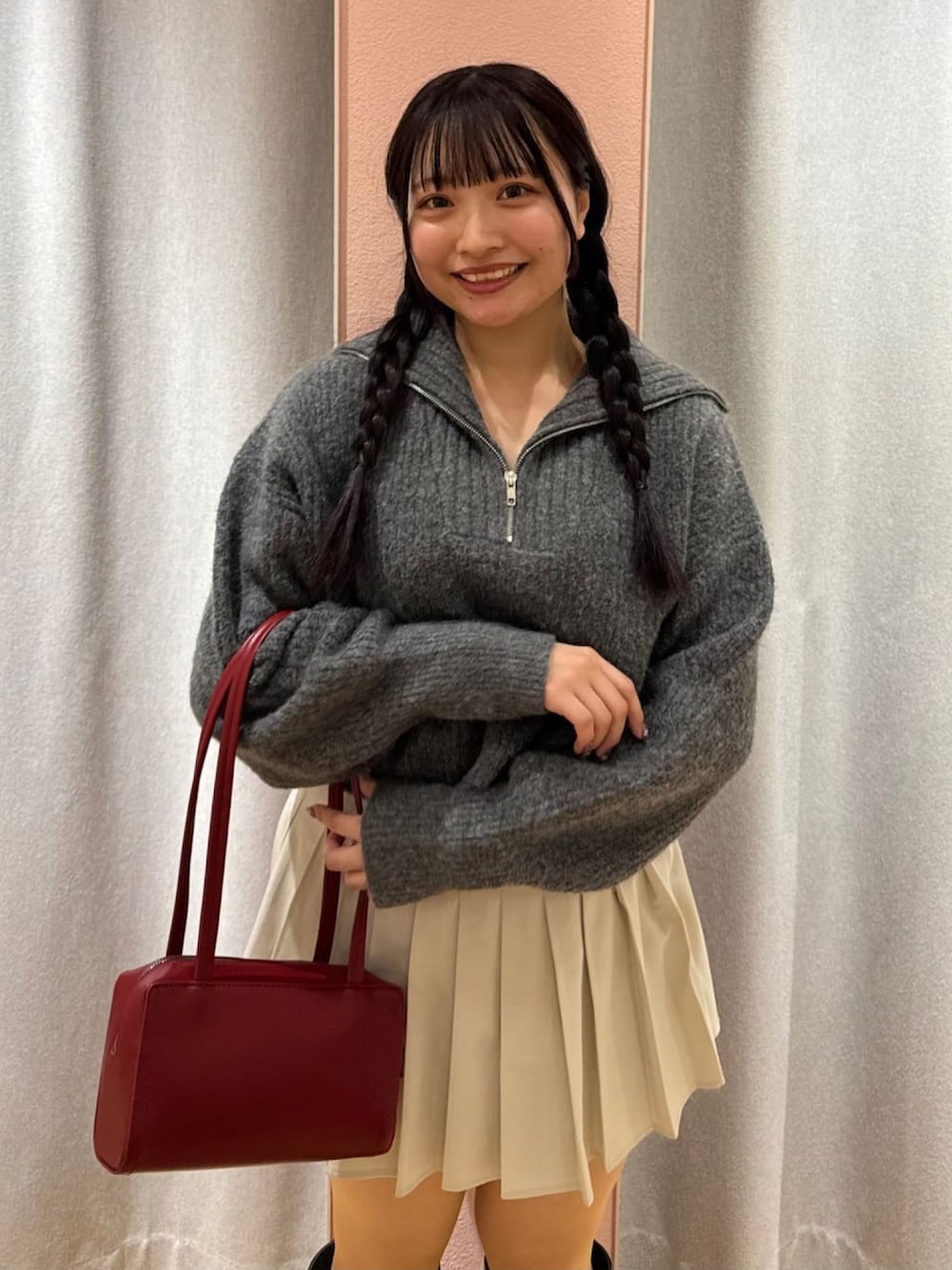 ブラック系のニット/セーター、グレー系のスカート、レッド系のショルダーバッグを着用したレディースの冬コーディネートの3枚目の写真