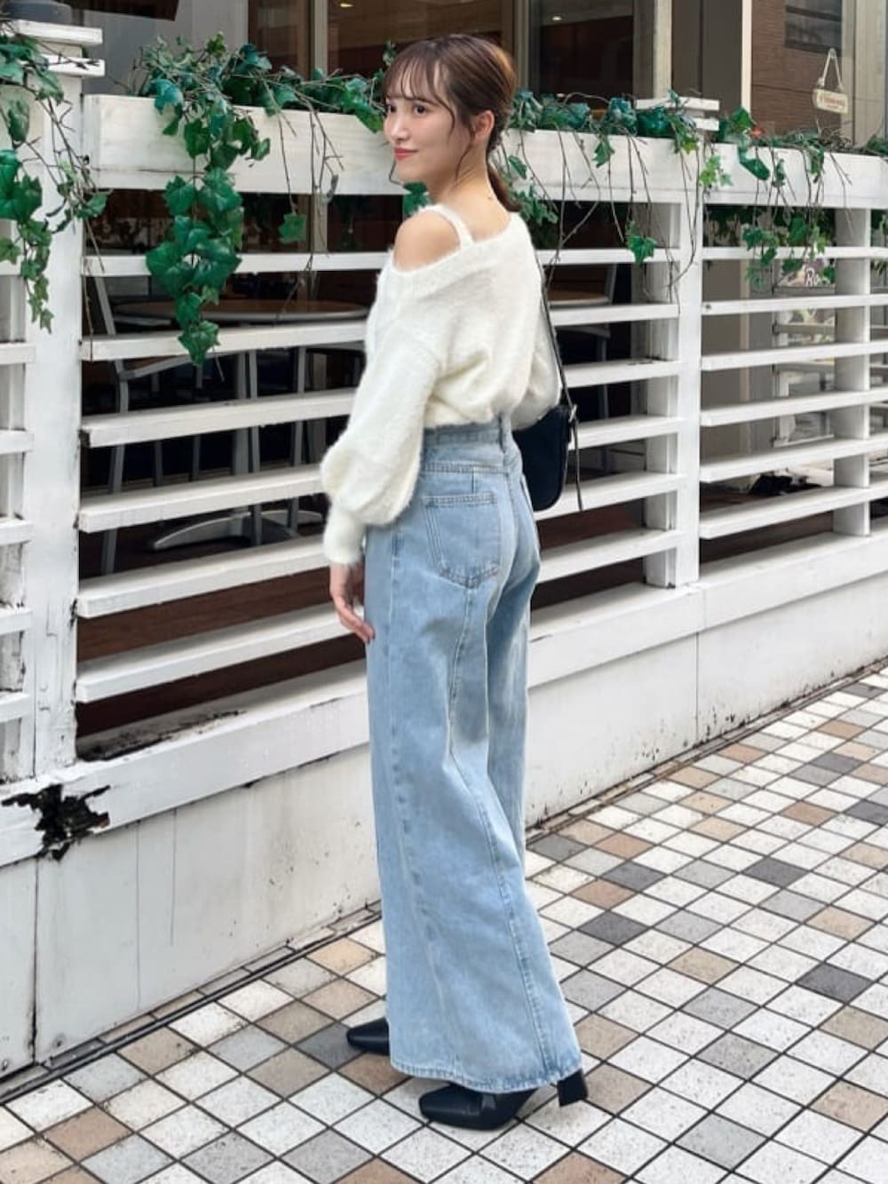ホワイト系のニット/セーター、ブルー系のデニムパンツを着用したレディースの秋コーディネートの2枚目の写真