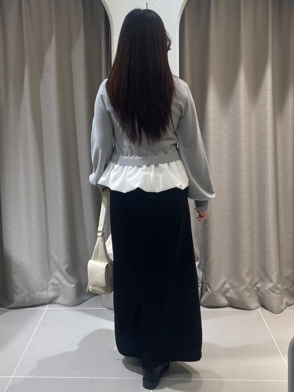 グレー系のニット/セーター、ブラック系のスカートを着用したレディースの冬コーディネートの3枚目の写真