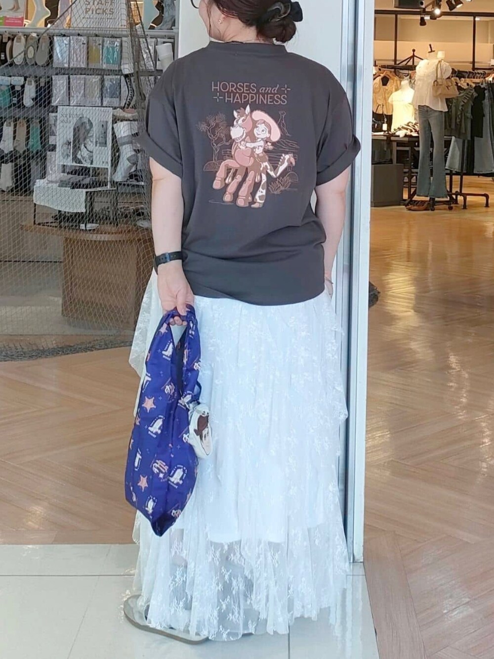 グレー系のTシャツ/カットソー、ブルー系のエコバッグ/サブバッグ、ホワイト系のスカートを着用したレディースの夏コーディネートの3枚目の写真