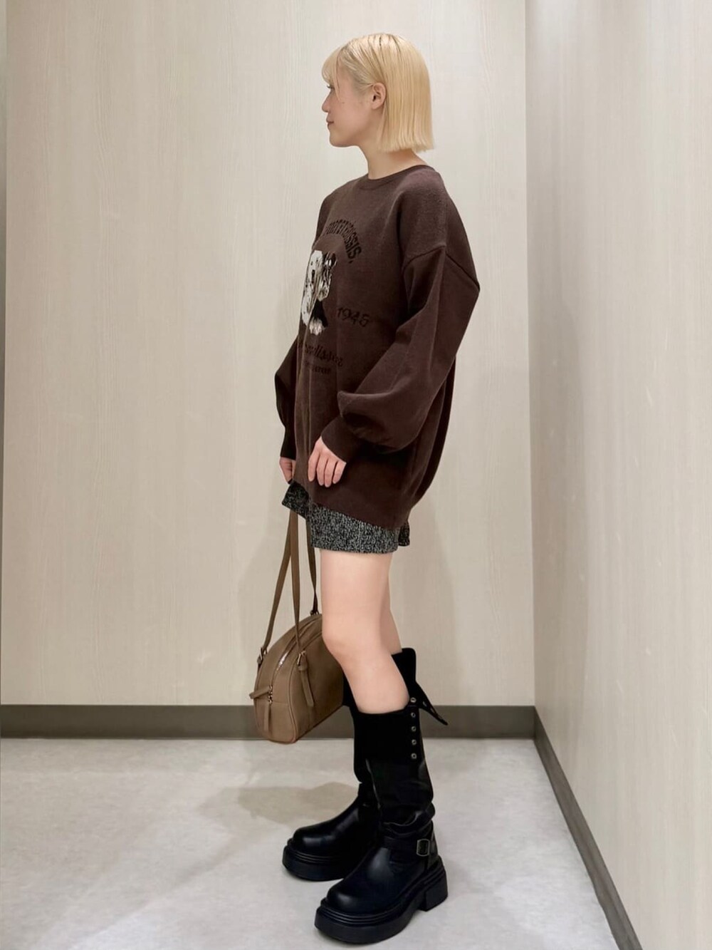 ブラウン系のニット/セーター、グレー系のその他パンツ、ブラック系のブーツを着用したレディースの秋コーディネートの2枚目の写真