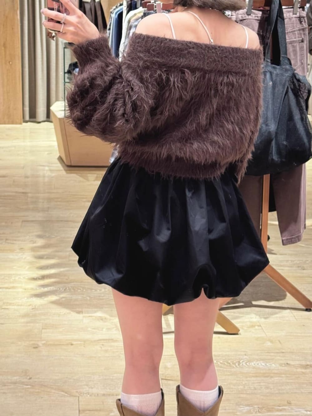 ブラウン系のニット/セーター、ブラック系のスカート、イエロー系のブーツを着用したレディースの秋コーディネートの3枚目の写真